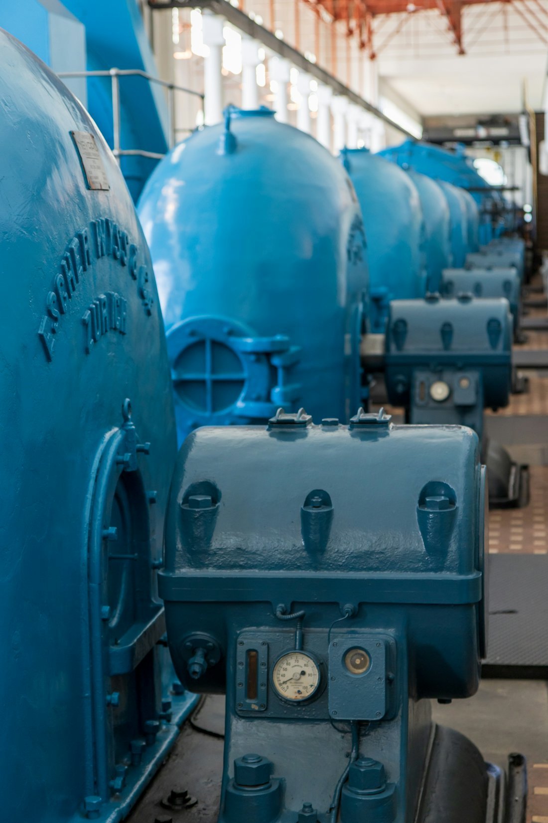 Row of blue industrial pumps in a plant room