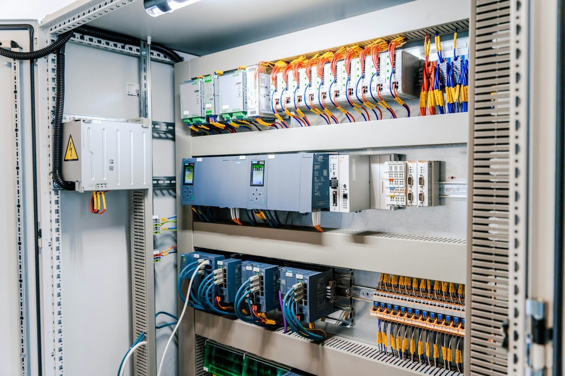 Open industrial control panel with PLC modules and wiring
